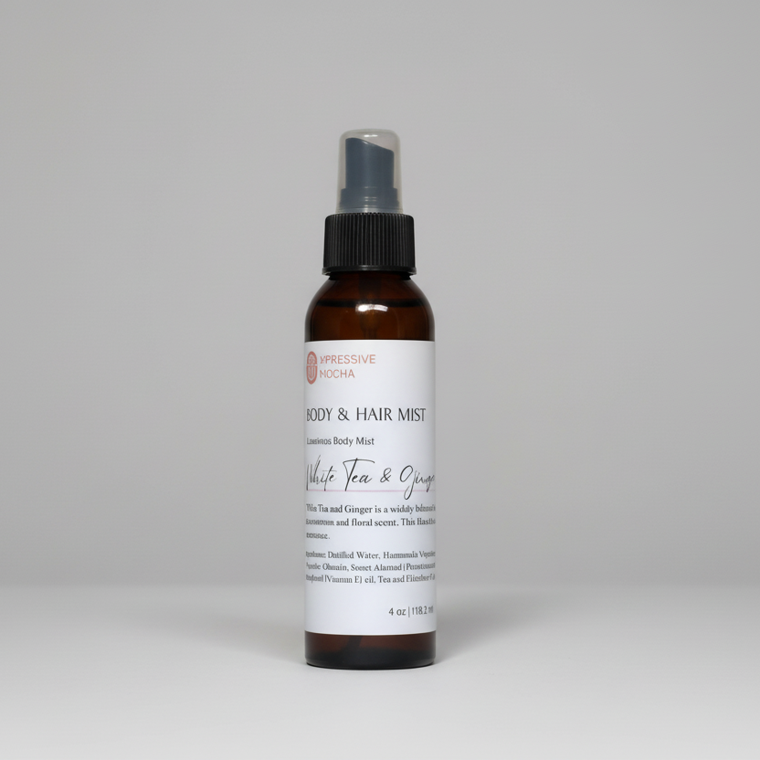 A spray bottle labeled 'White Tea & Ginger Bliss Aura Mist' with black text on a white label, indicating it is a body and hair mist.